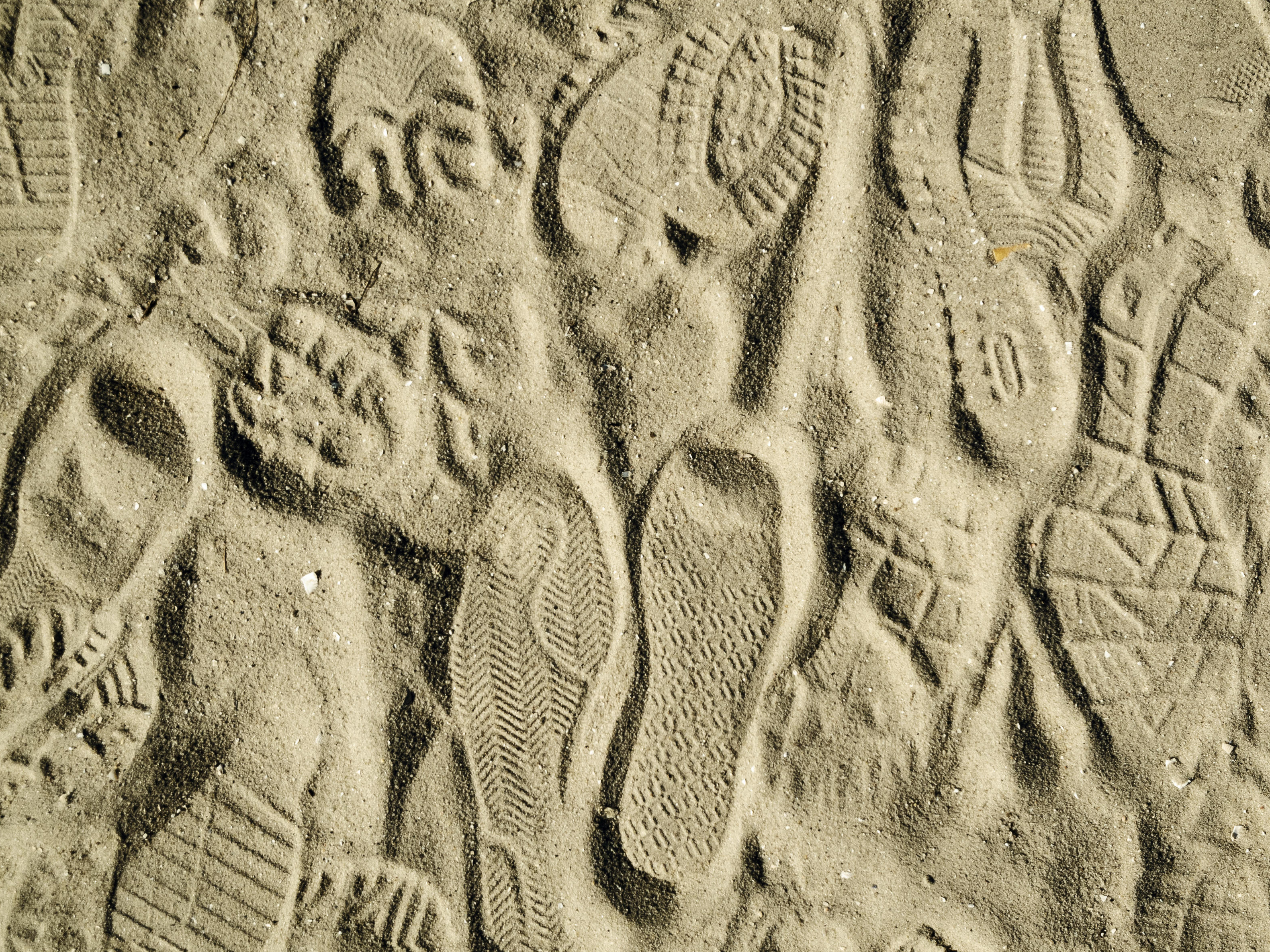 Vorschaubild mit verschiedenen Schuhabdrücken im Sand