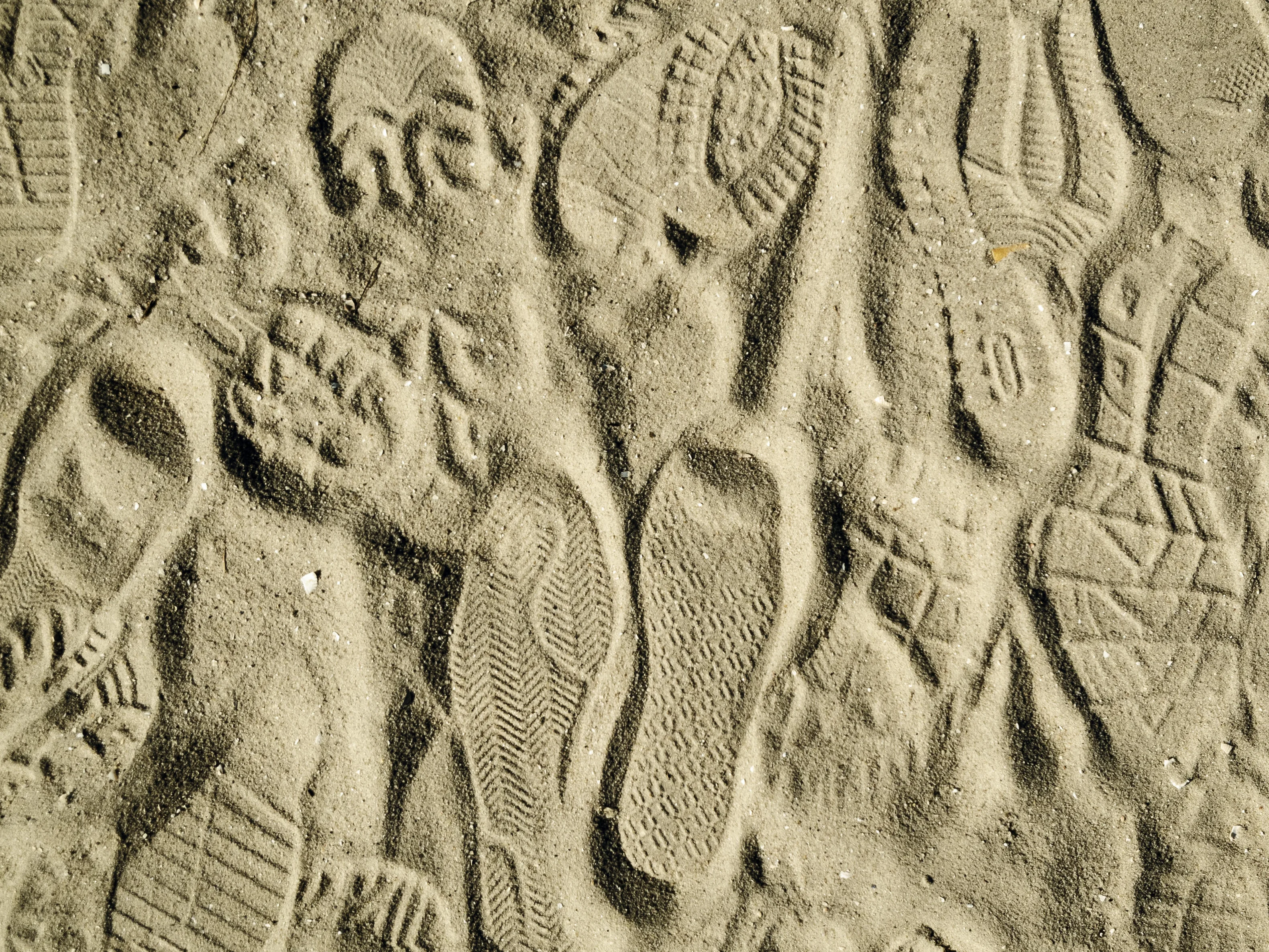 Vorschaubild mit verschiedenen Schuhabdrücken im Sand