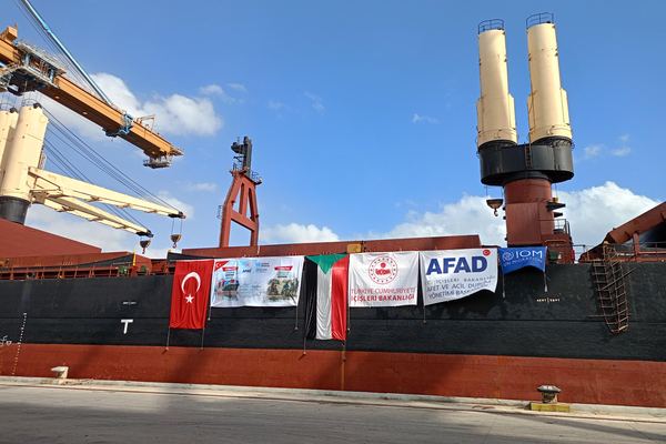 Schiff am Hafen von Port Sudan mit Hilfsgütern ausd er Türkei. Es hängen Plakate der Hilfsorganisation und Flaggen von Sudan und Türkei am Schiff.
