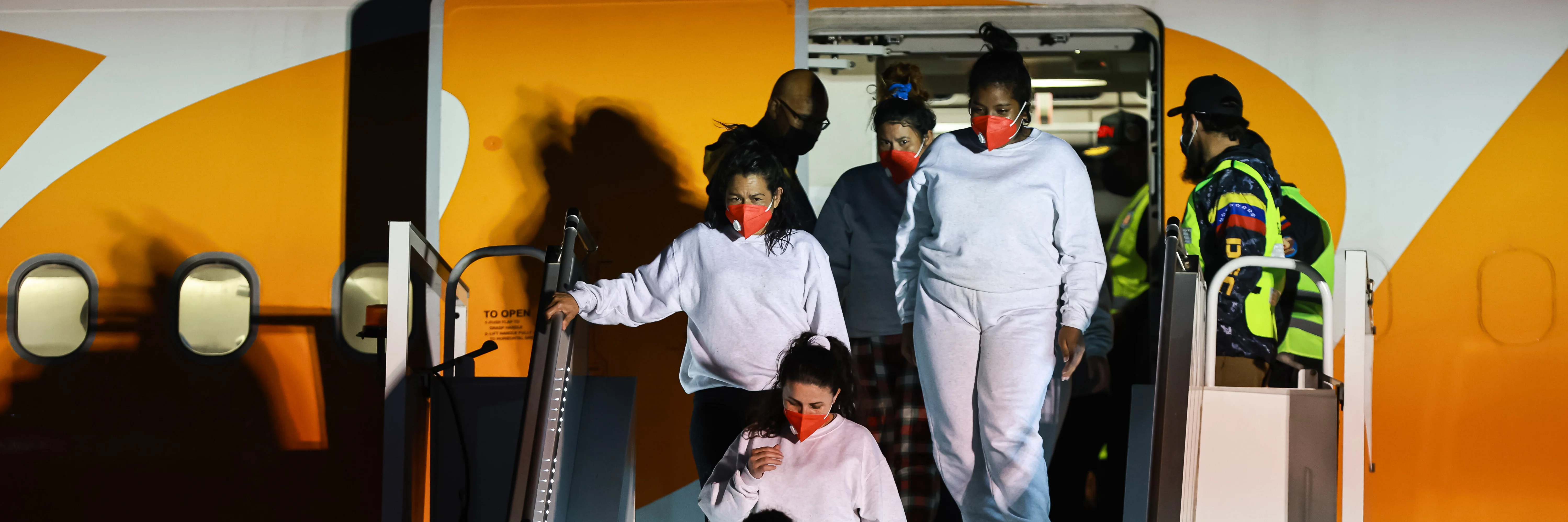 Aus den USA abgeschobene Venezolanerinnen kommen mit einem Rückführungsflug am internationalen Flughafen in Caracas an.