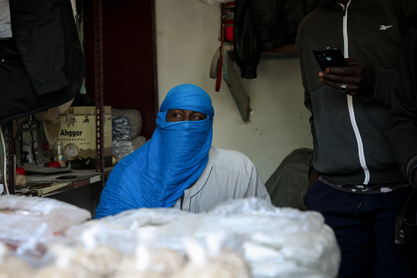 Arbeitsmigrant in Tripolis Libyen an einem Verkaufstand mit leuchtend blauem Turban.