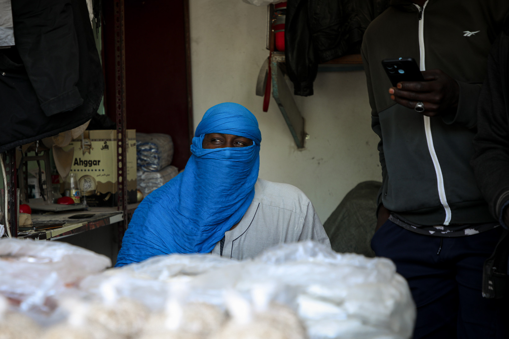 Arbeitsmigrant in Tripolis Libyen an einem Verkaufstand mit leuchtend blauem Turban.