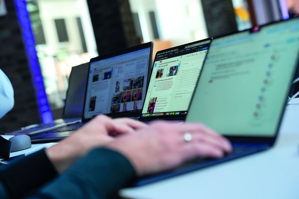 Foto von drei Laptops, die nebeneinander auf einem Tisch stehen.