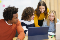 4 Personen vor zwei Laptops planen gemeinsam