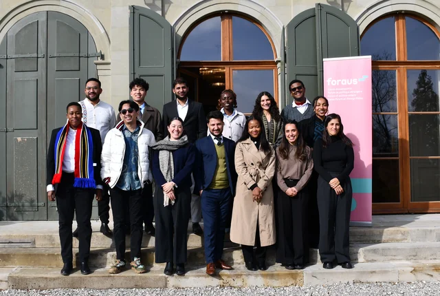 Gruppenbild der GenSouth-Teilnehmenden vor dem Veranstaltungort. Alle lächeln. 