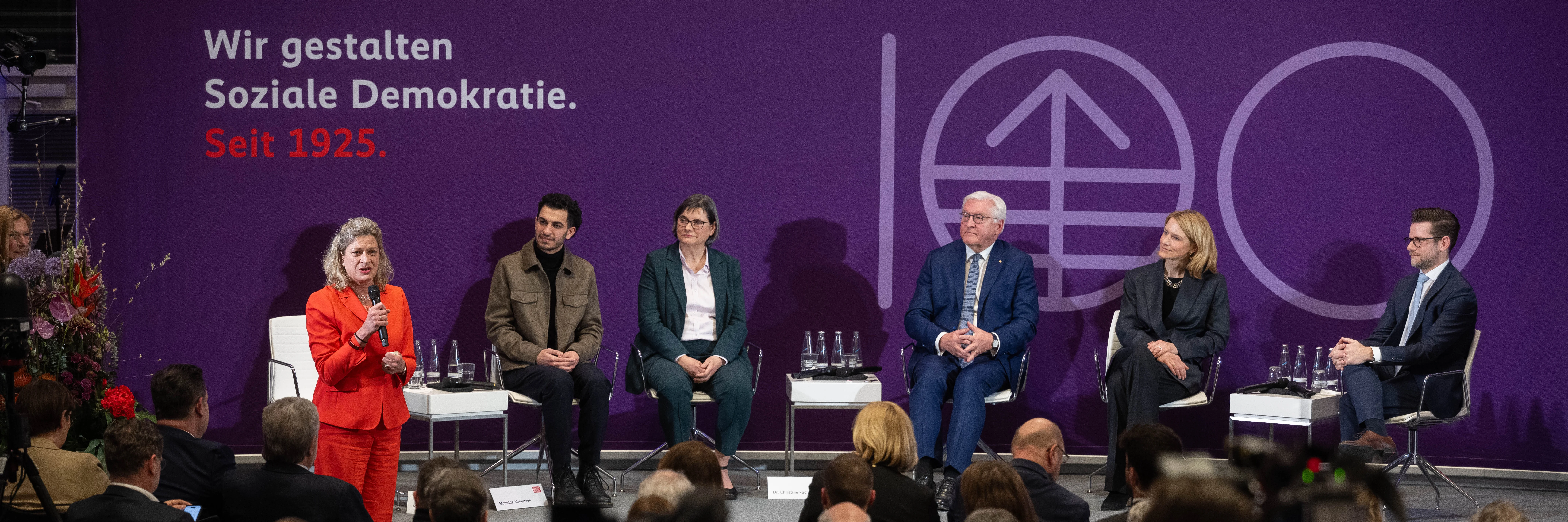 Sabine Fandrych auf der Bühne der Friedrich-Ebert-Stiftung gemeinsam mit weiteren Gästen einer Jubiläumsveranstaltung. Im Hintergrund steht der Text "Wir gestalten Soziale Demokratie. Seit 1925."