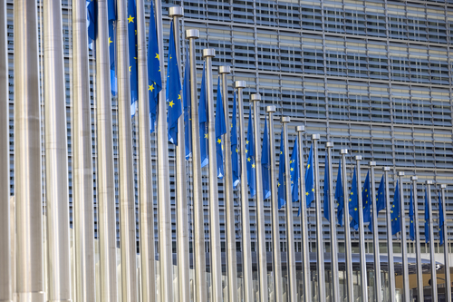Flaggenreihe mit dem Symbol der EU vor dem Gebäude der Europäischen Kommission in Brüssel