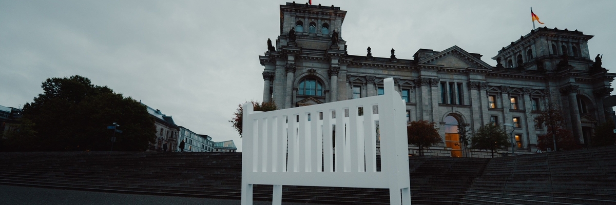 Eine leere Wiege steht vorm deutschen Bundestag.