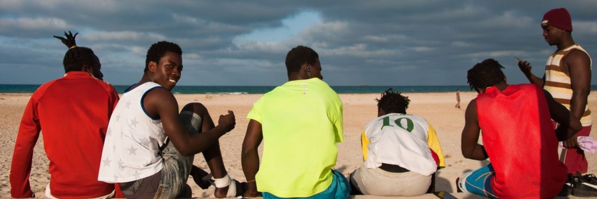Migrants prepare to play a football match on the beach.