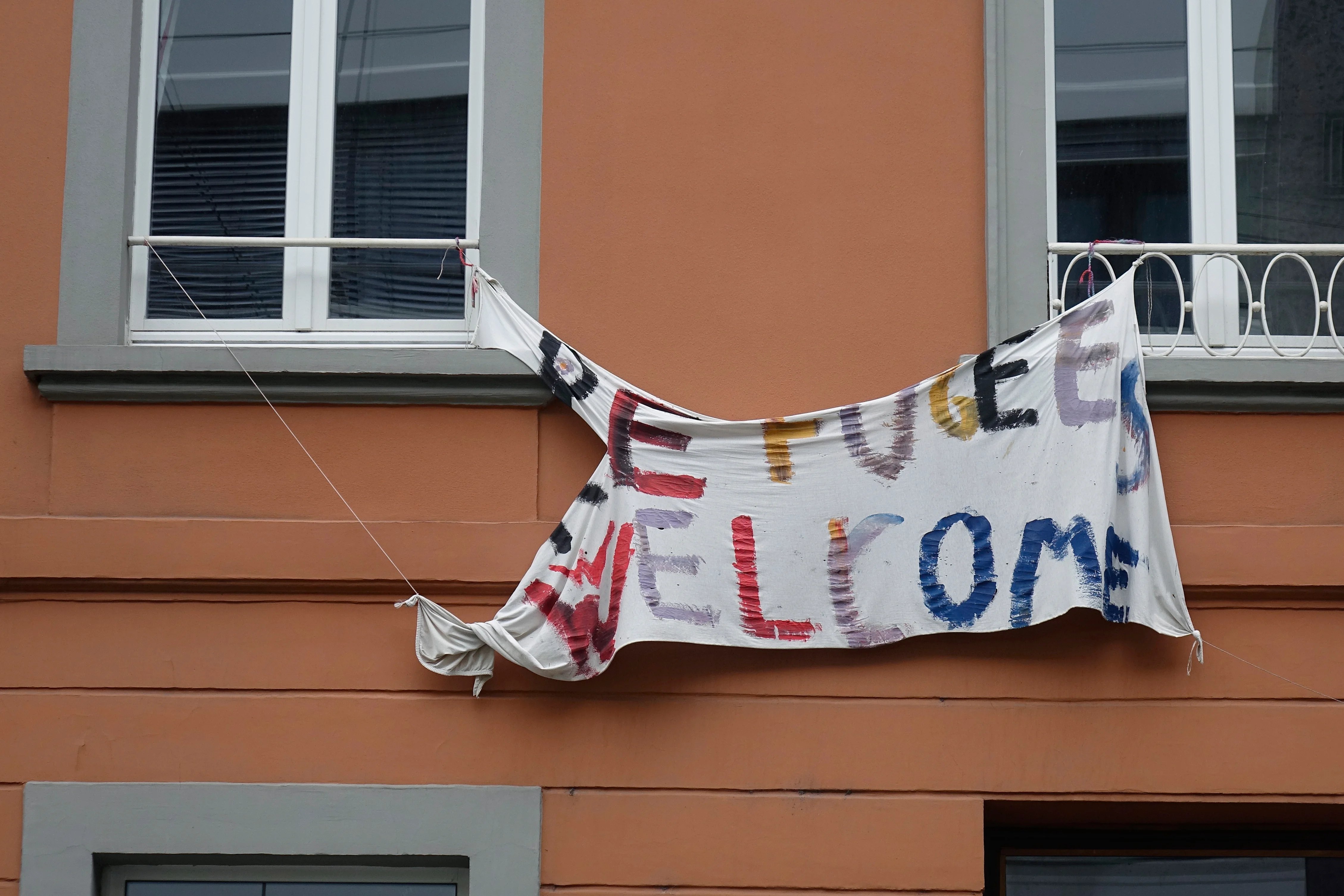 An einem Haus in Bonn hängt ein durch die Witterung zerrissenes Transparent.