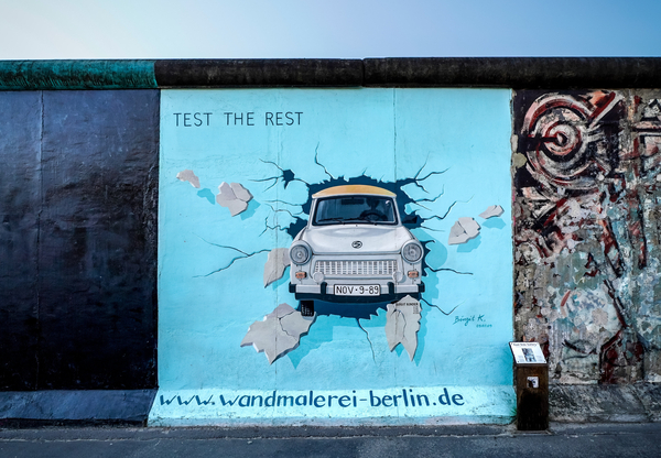 Ein Stück Berlinermacher mit einem Bild von einem Trabi, welcher durch die Mauer hindurchbricht.