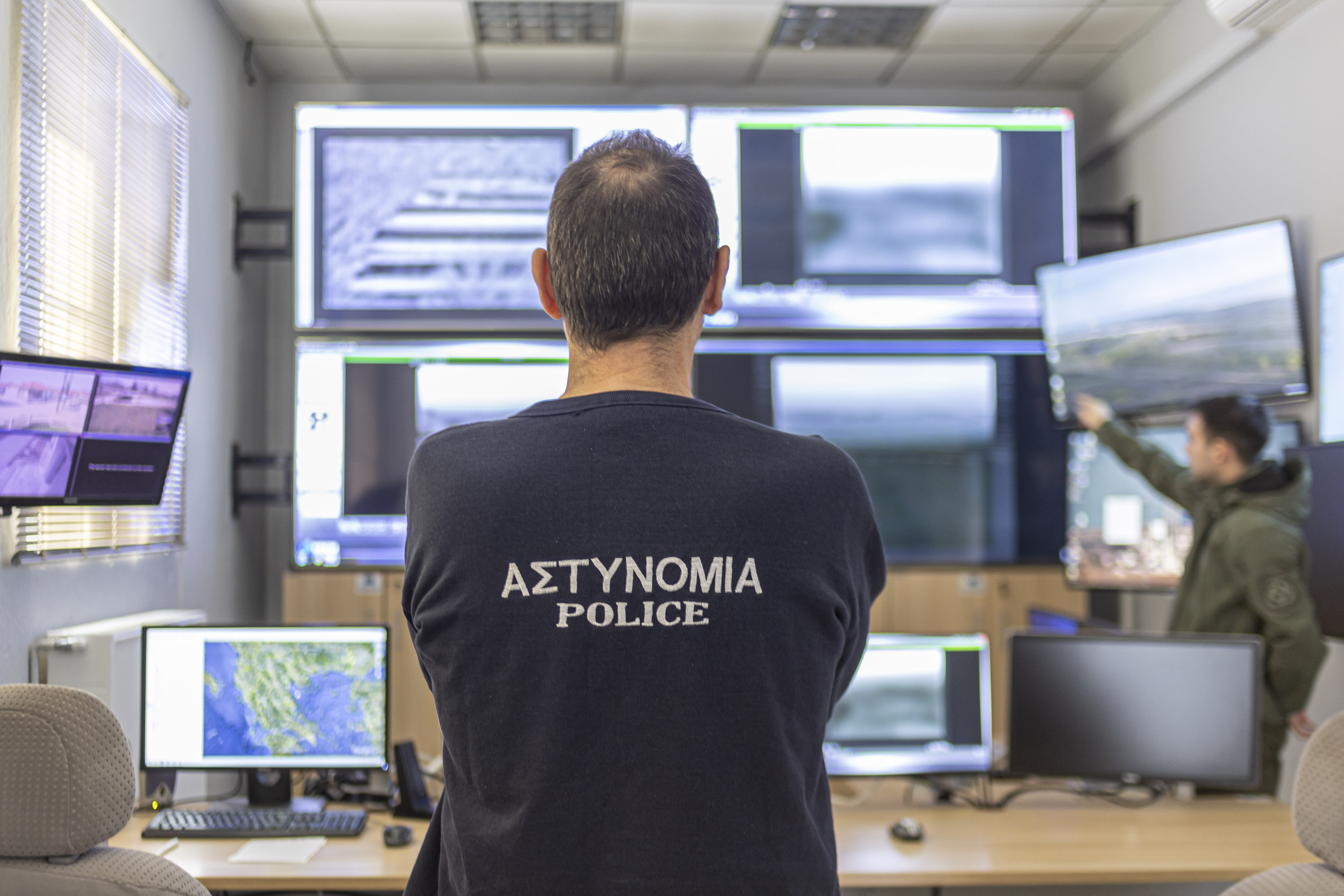 Polizist steht vor Überwachungsmonitoren