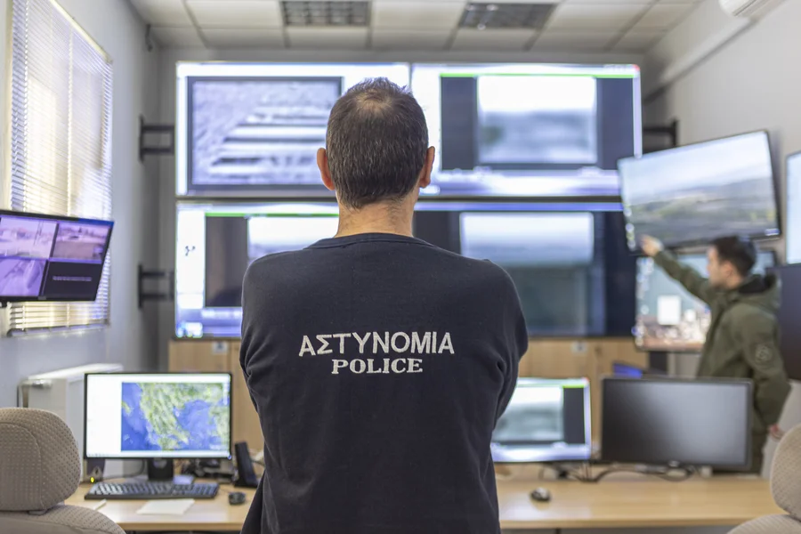 Polizist steht vor Überwachungsmonitoren