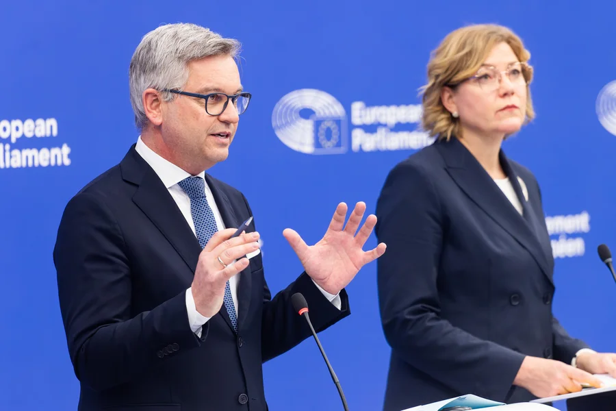 Magnus Brunner und Henna Virkkunen stehen im Gebäude des Europäischen Parlaments und sprechen über die von der EU-Kommission vorgeschlagene Rückführungsrichtlinie.