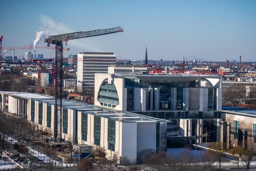 Sicht auf das Bundeskanzleramt in Berlin im Winter mit einem Baukran daneben.