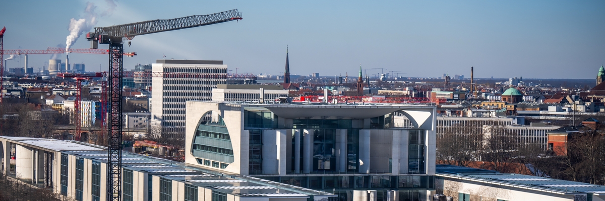 Sicht auf das Bundeskanzleramt in Berlin im Winter mit einem Baukran daneben.