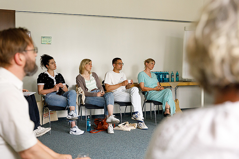 Gruppe von Seminarteilnehmern schauen gespannt zum Trainer. 
