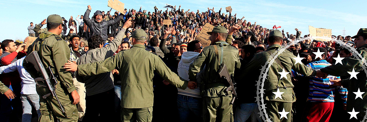 Auf dem Bild sieht man, wie Soldaten der tunesischen Armee versuchen, Ägypter während einer Protestaktion eines Flüchtlingslagers in der Nähe des libyschen und tunesischen Grenzübergangs Ras Jdir zu beruhigen, nachdem sie am 28. Februar 2011 vor den Unruhen in Libyen geflohen waren.