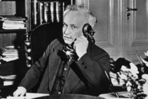 Carl Severing sitzt an einem Schreibtisch und telefoniert.