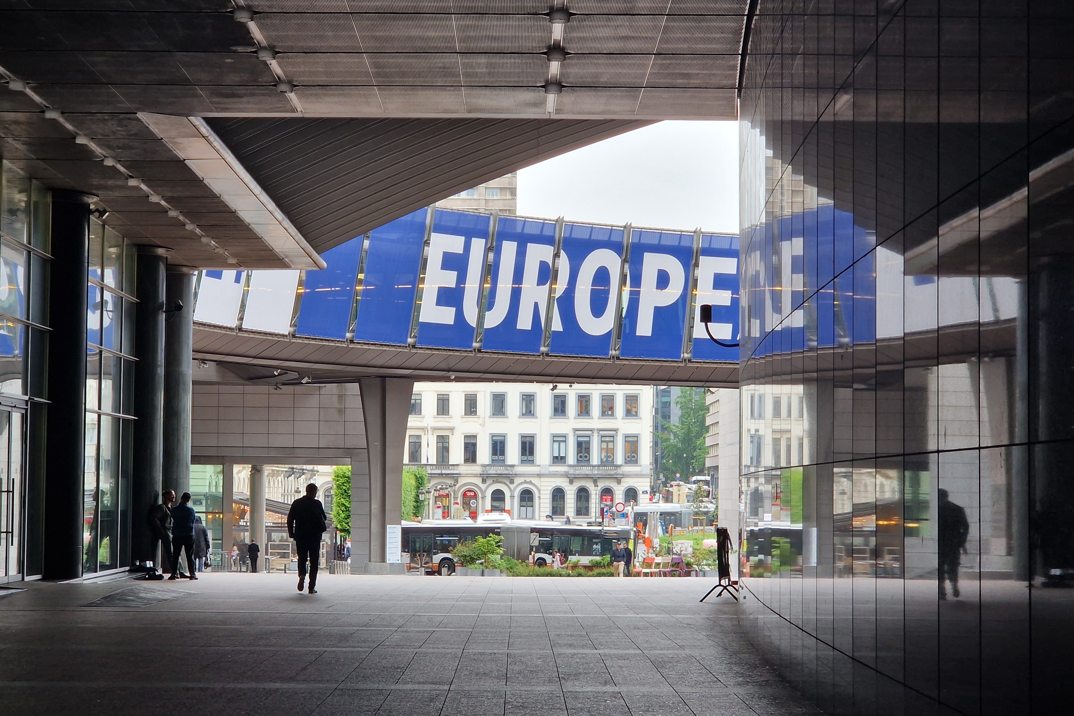 Blick durch einen Fußgängerdurchgang am EU-Parlament in Brüssel auf ein Plakat mit dem Wort Europe.
