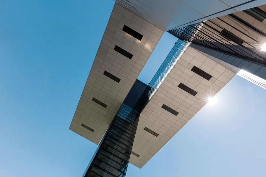 Ansicht von unten nach oben auf blauen Himmel und eines der Kölner Kranhäuser aus Stahl und Glas