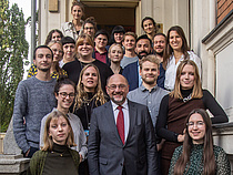 FES-Vorsitzender Martin Schulz und die Teilnehmer_innen des Bundestagshospitanzprogramms stehen zu einem Gruppenbild auf einer Treppe zusammen.