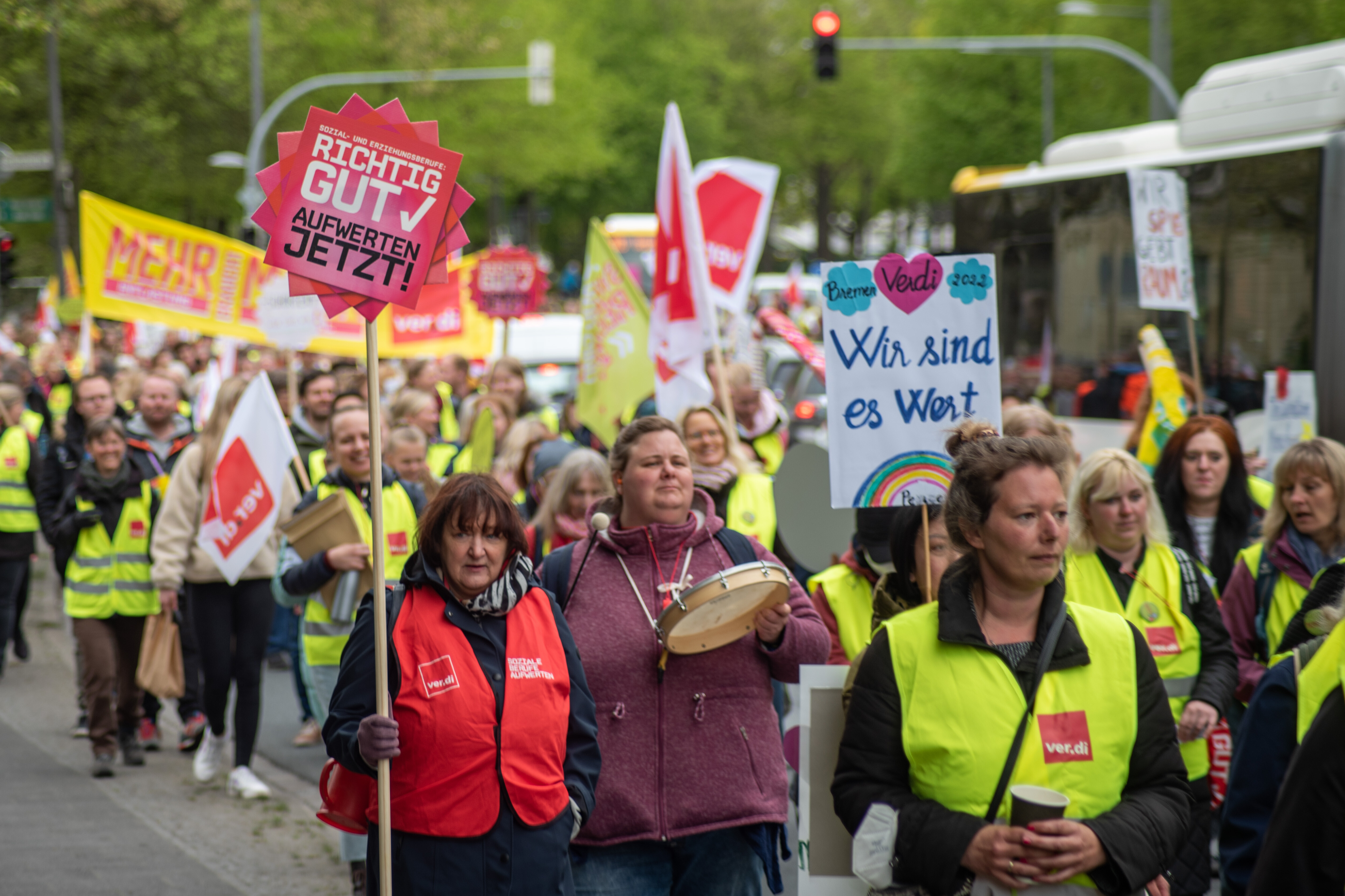 Menschen auf einer Demo von Verdi halten Schilder hoch mit Aufschriften wie "Wir sind es wert"