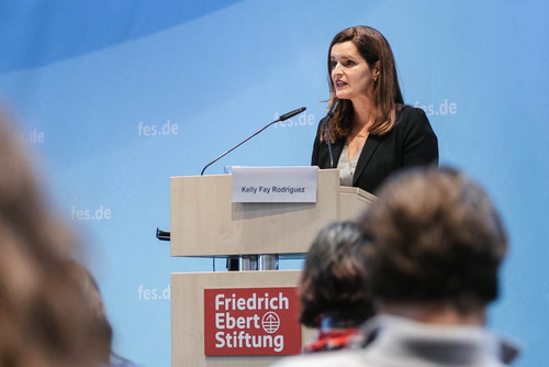 Kelly Fay Rodriguez hält eine Rede auf einem Podium der Friedrich-Ebert-Stiftung. Vor ihr sitzt das Publikum. 