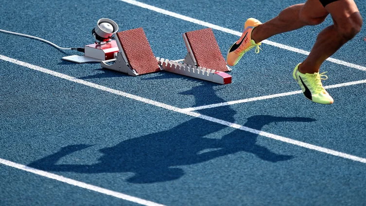 Foto: Startblock mit Beinen und Schatten eines Läufers 