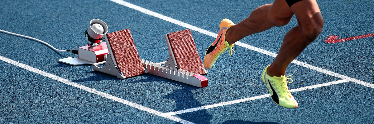 Foto: Startblock mit Beinen und Schatten eines Läufers 