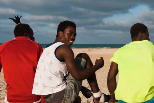 Migrants prepare for a football match at the beach.