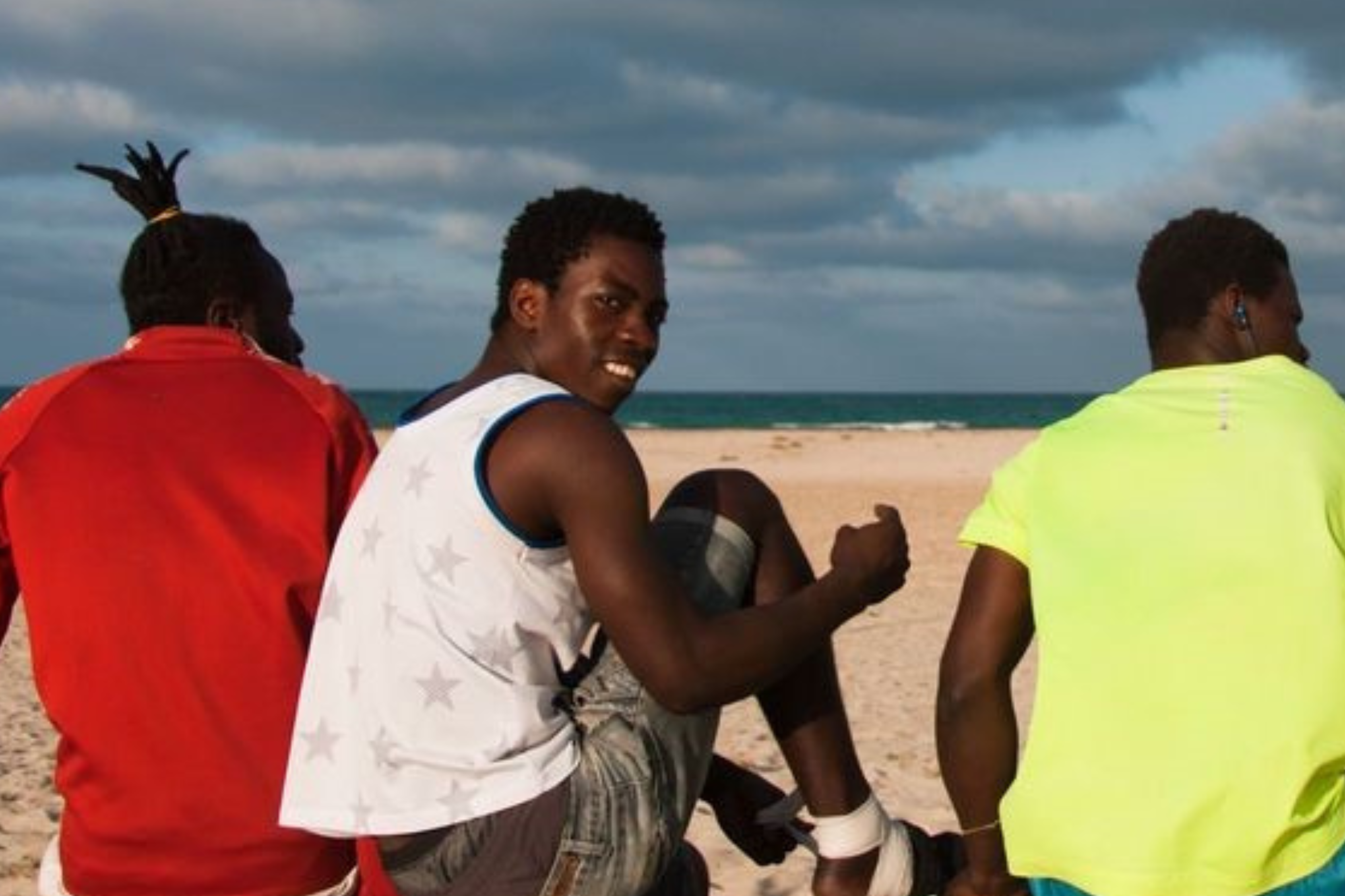 Migranten bereiten sich auf ein Fußballspiel am Strand vor