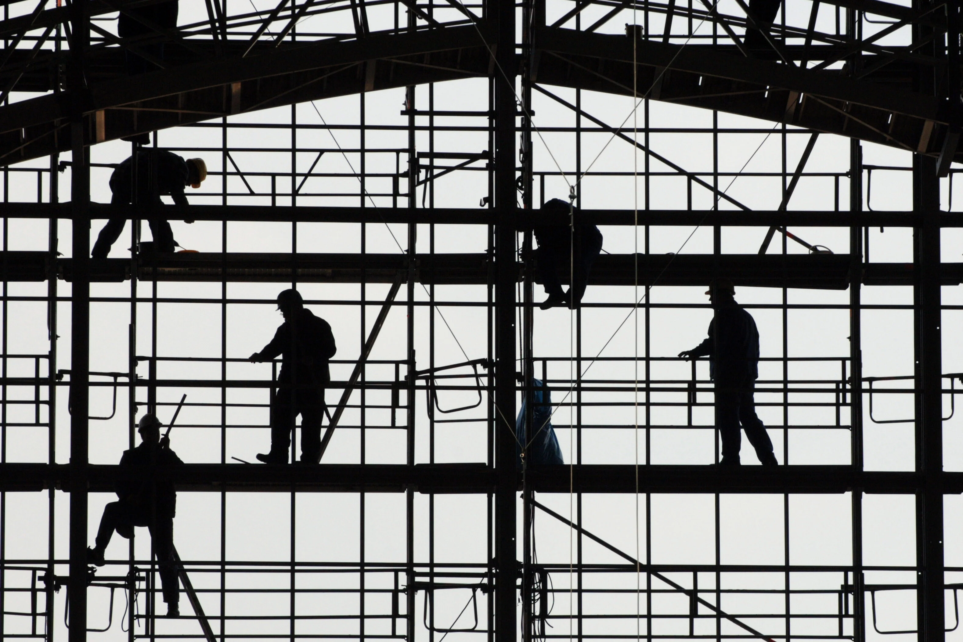 Silhouetten von Bauarbeitern auf einem Gerüst