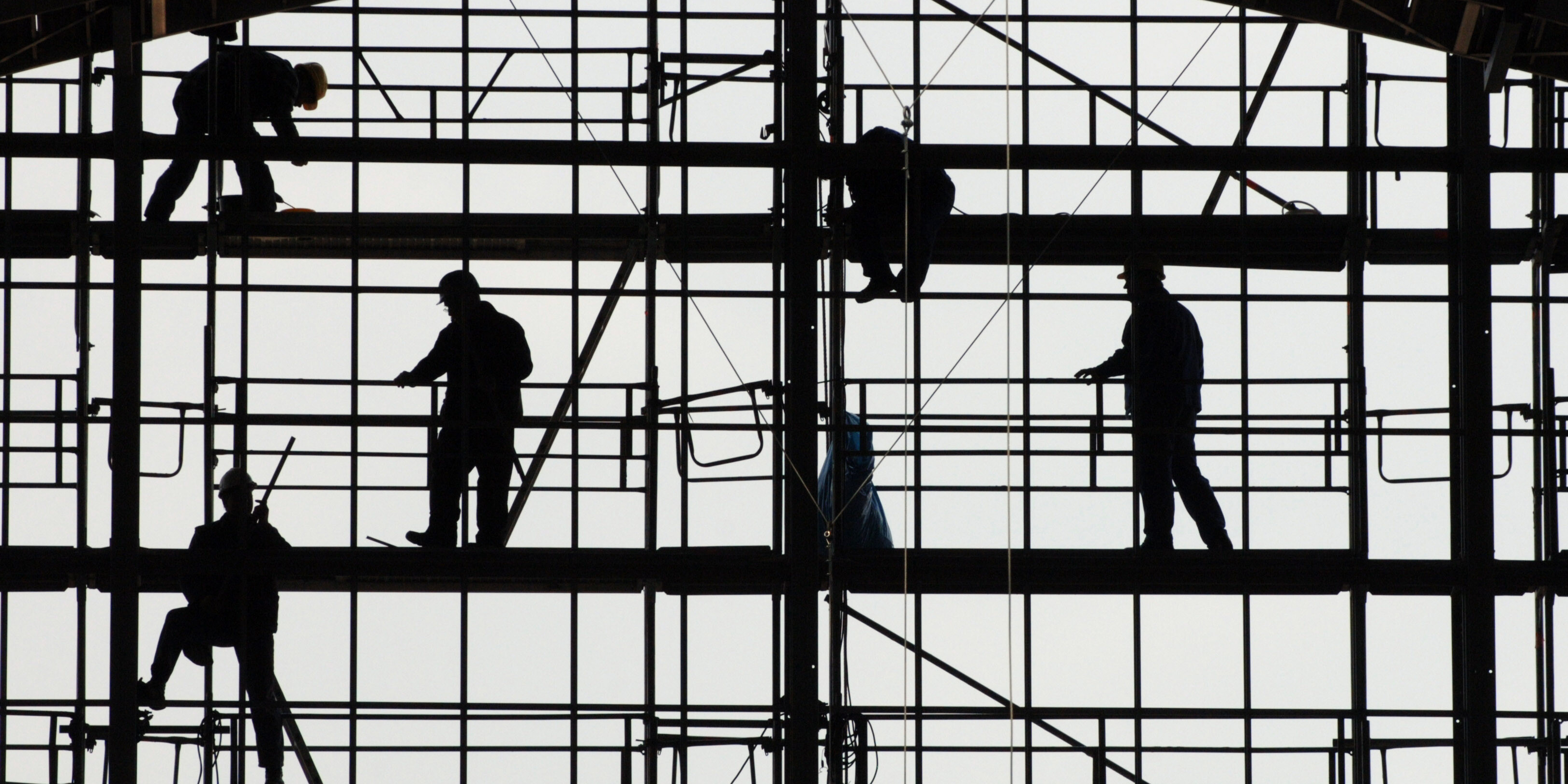 Silhouetten von Bauarbeitern auf einem Gerüst