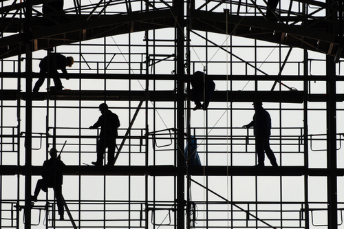 Silhouetten von Bauarbeitern auf einem Gerüst