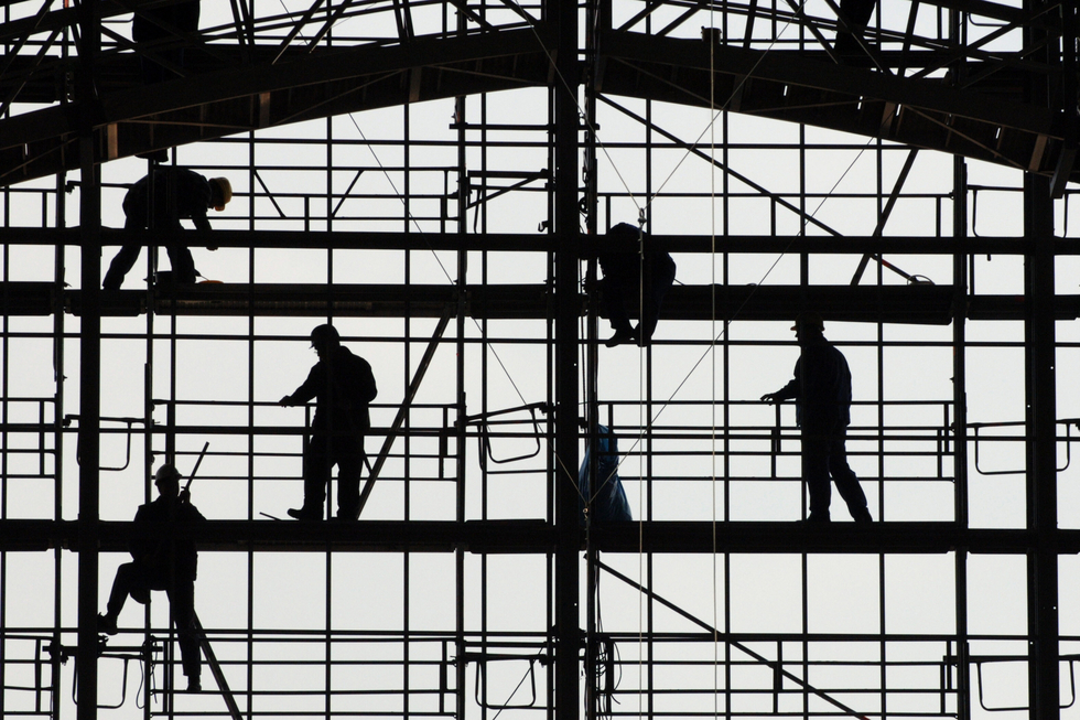 Silhouetten von Bauarbeitern auf einem Gerüst