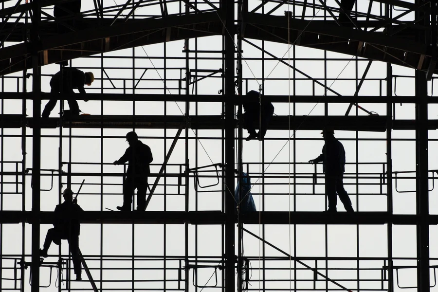 Silhouetten von Bauarbeitern auf einem Gerüst