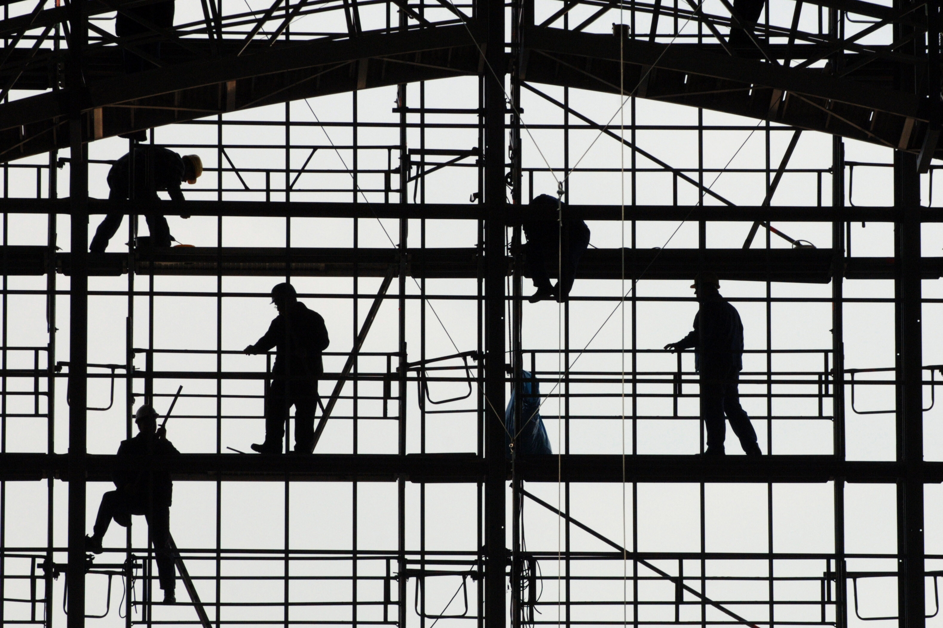 Silhouetten von Bauarbeitern auf einem Gerüst