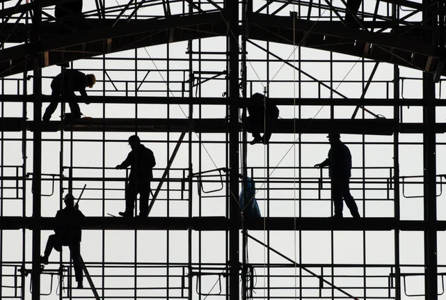 Silhouetten von Bauarbeitern auf einem Gerüst