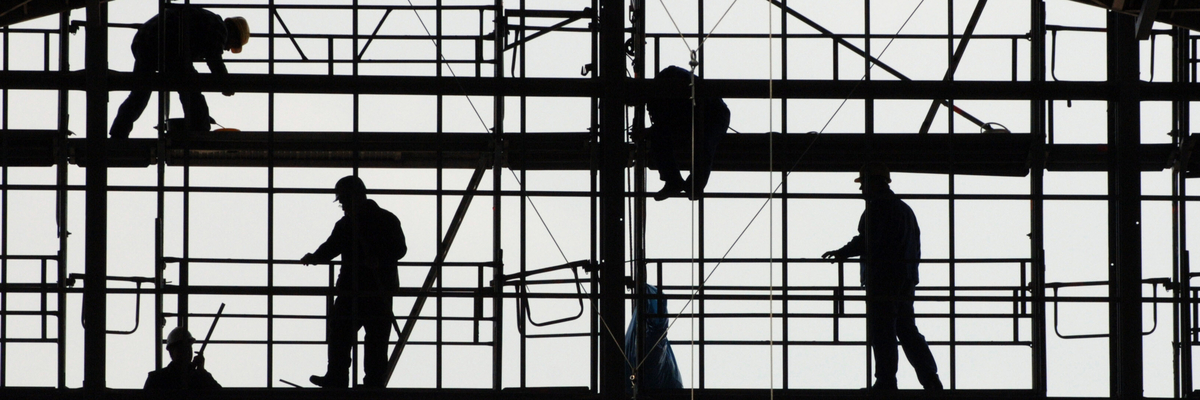 Silhouetten von Bauarbeitern auf einem Gerüst