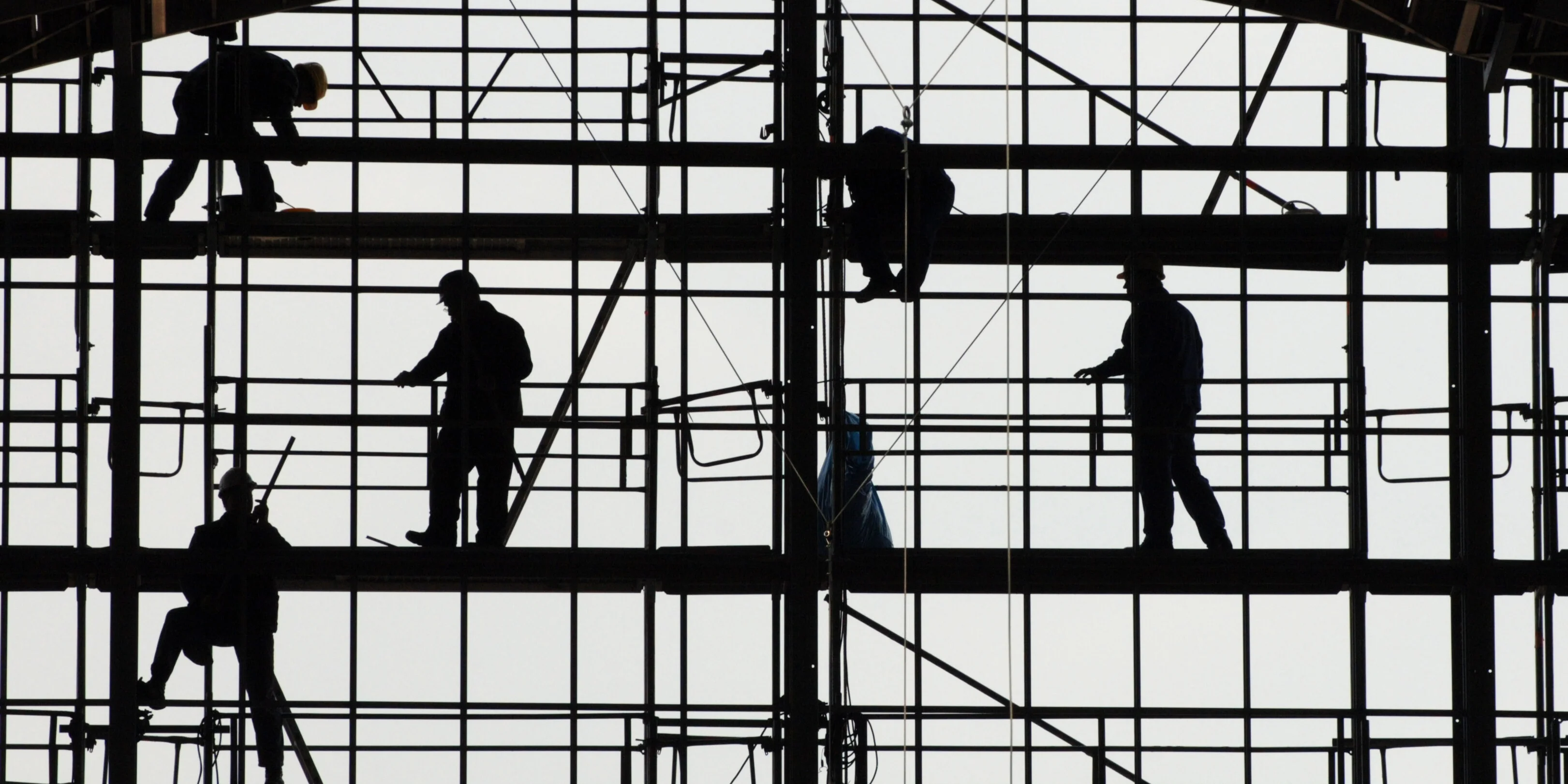 Silhouetten von Bauarbeitern auf einem Gerüst