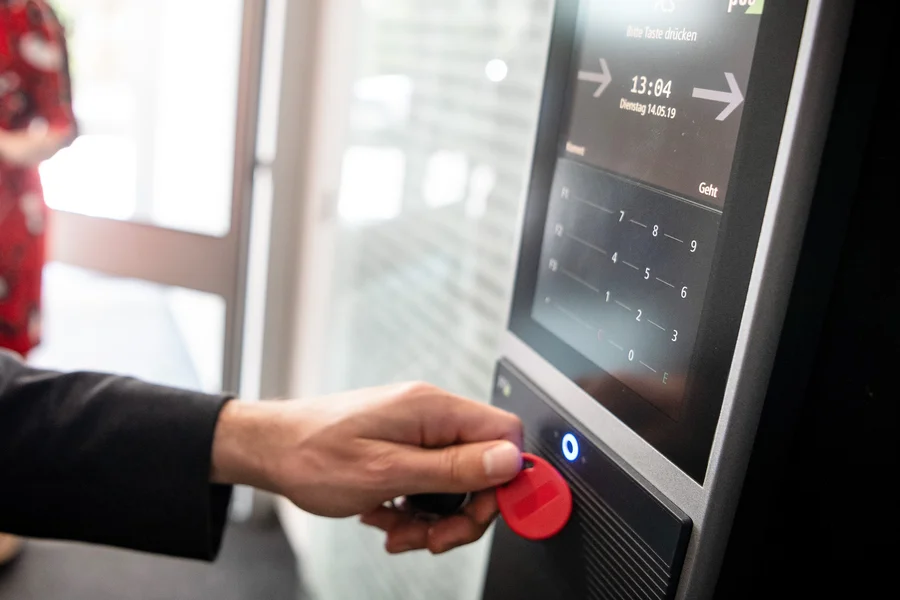 Person die sich mit einem Arbeitszeitchip auf der Arbeit registriert.