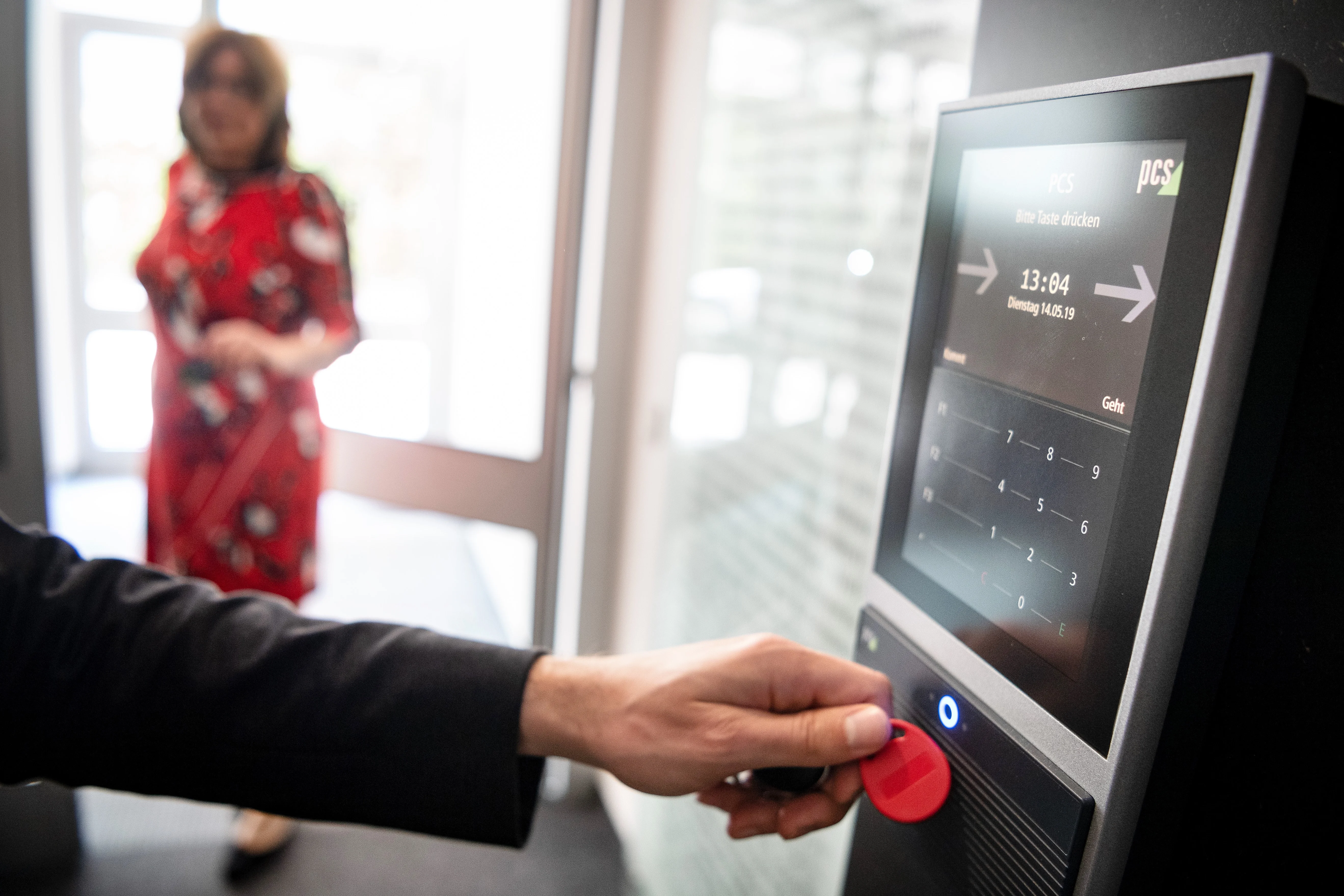 Person die sich mit einem Arbeitszeitchip auf der Arbeit registriert.