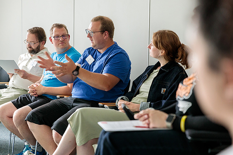 Seminargruppe im Gespräch: Zwei Männer und eine Frau. 