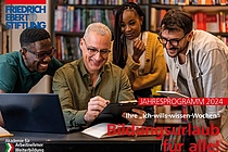 4 Personen, die lächelnd auf ein Dokument schauen