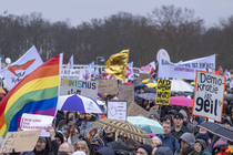 Menschen mit bunten Plakaten, die gegen Rechtsextremismus demonstrieren. Auf den Plakaten steht unter anderem Demokratie ist geil