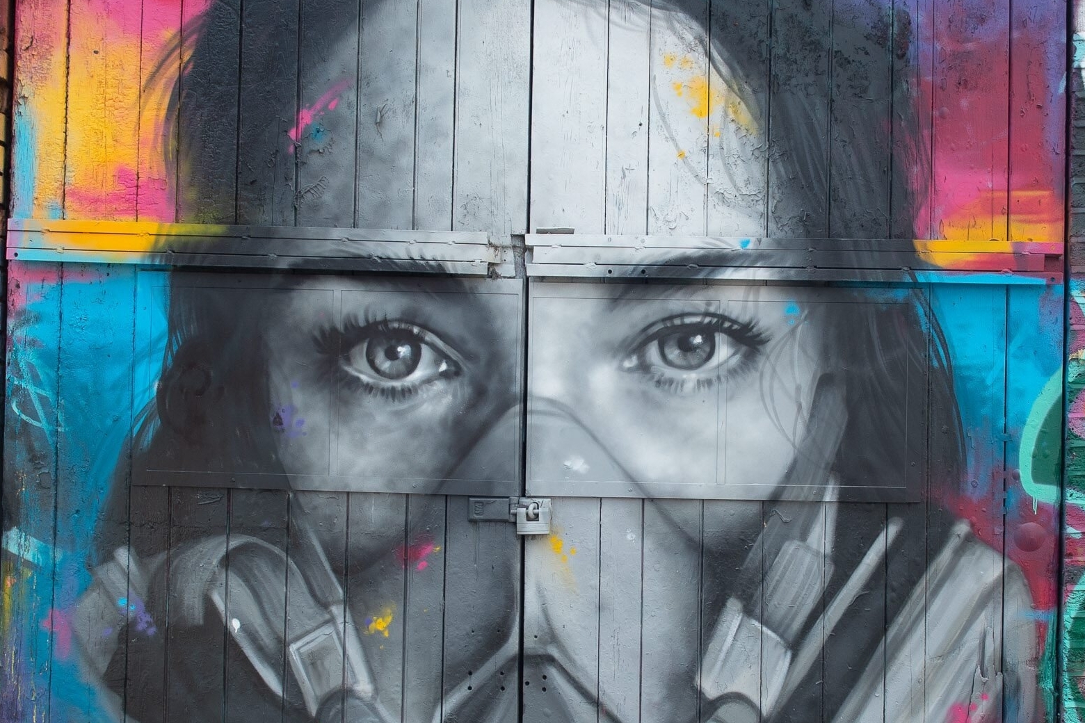 Das Graffiti des Straßenkünstlers Zabou zeigt eine junge Frau mit Maske.