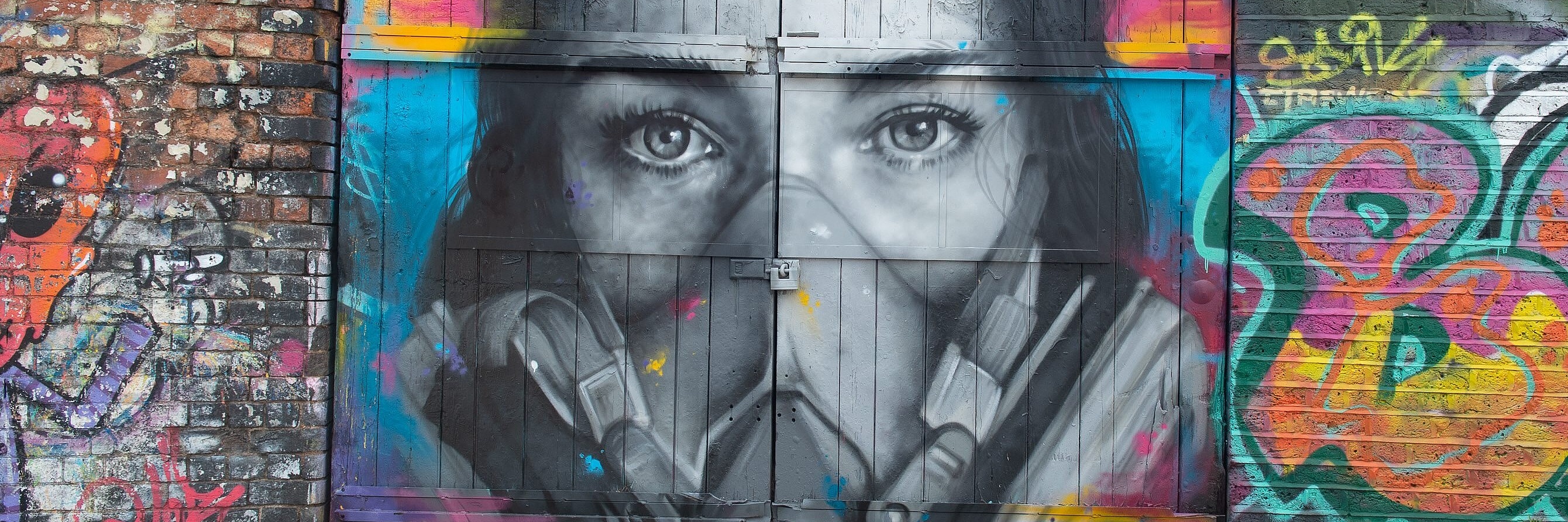 Das Graffiti des Straßenkünstlers Zabou zeigt eine junge Frau mit Maske.