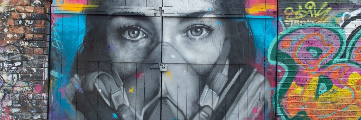 Das Graffiti des Straßenkünstlers Zabou zeigt eine junge Frau mit Maske.