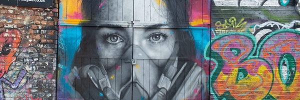 Das Graffiti des Straßenkünstlers Zabou zeigt eine junge Frau mit Maske.